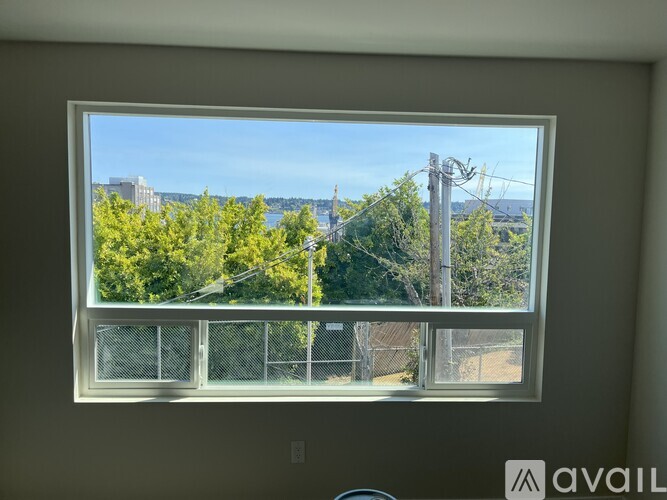 A window with a view of a cityscape and trees.