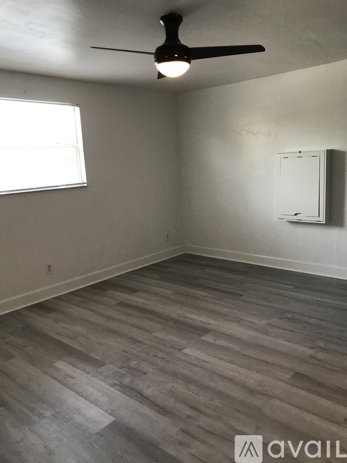 A room with a ceiling fan and a window.