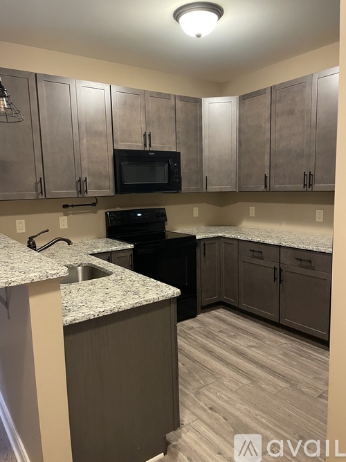 A kitchen with a granite countertop and wooden cabinets.