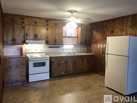 A kitchen with wooden cabinets and a white refrigerator.