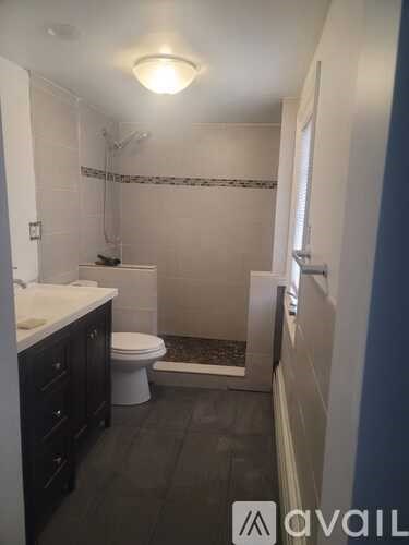 A bathroom with a toilet, sink, and shower.