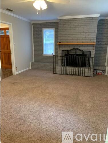 A living room with a fireplace and a window.