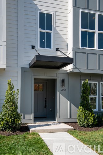 A white house with a grey door and windows.
