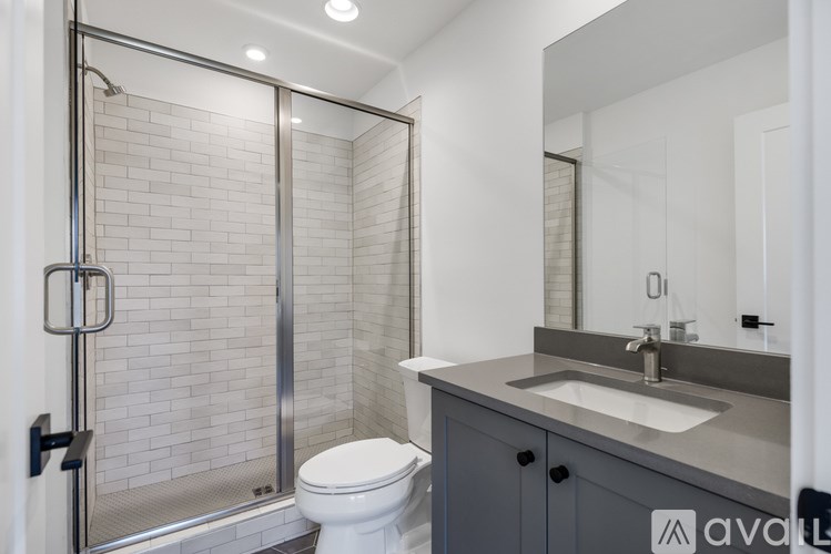 A bathroom with a toilet, sink, and shower.