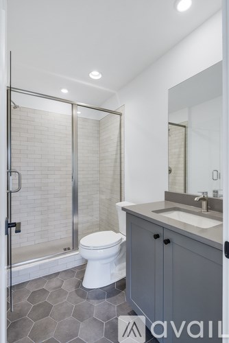 A bathroom with a toilet, sink, and shower.