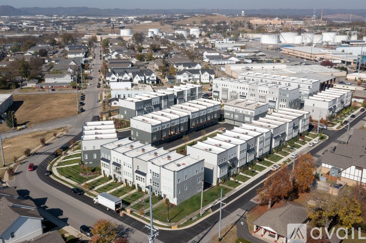 A large industrial building complex with a parking lot in front.