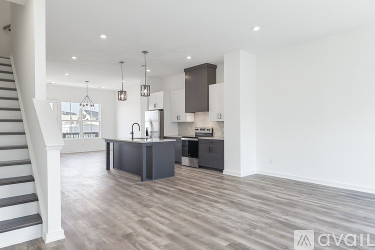 A modern kitchen with dark wood floors and white walls.