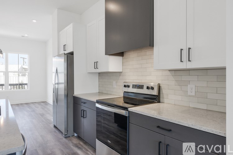 A modern kitchen with a stainless steel refrigerator and oven.
