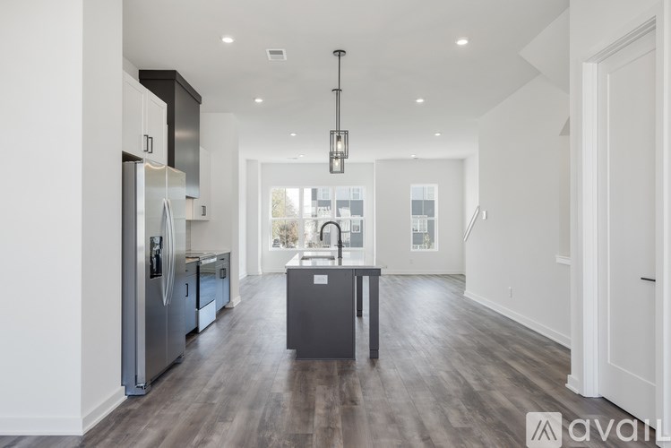 A modern kitchen with a dark wood floor and white walls.