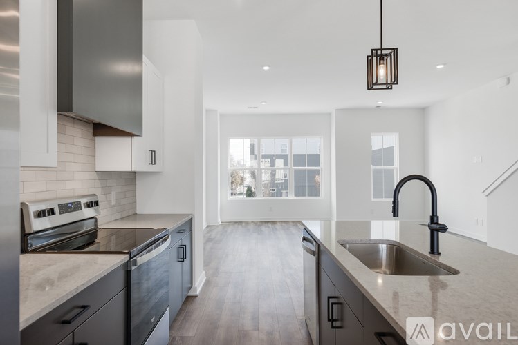 A modern kitchen with a stainless steel oven and a dark faucet.