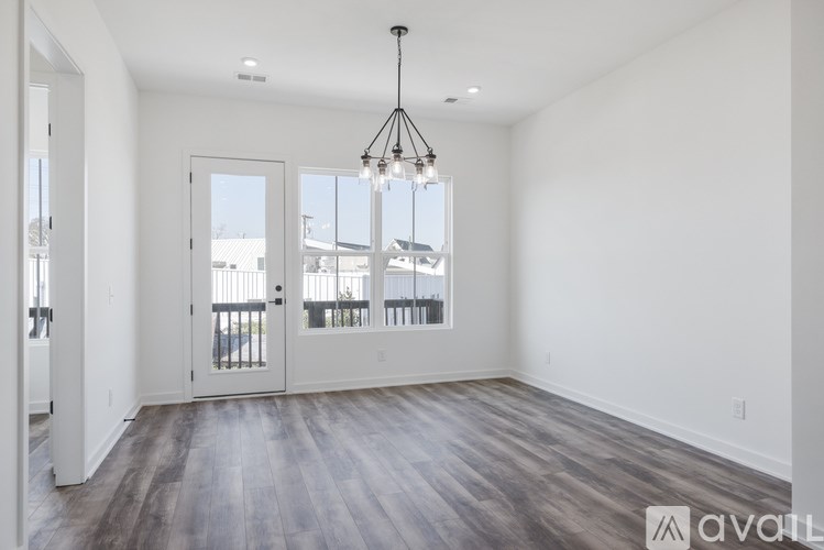A large empty room with a view of a balcony outside the door.