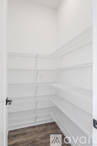 A white closet with shelves and a door.