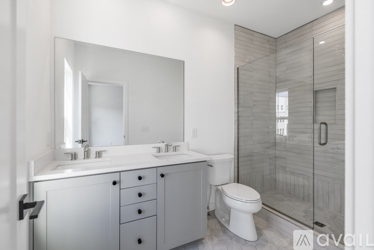 A bathroom with a white toilet and a large mirror.