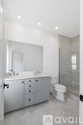 A bathroom with a toilet, sink, and mirror.
