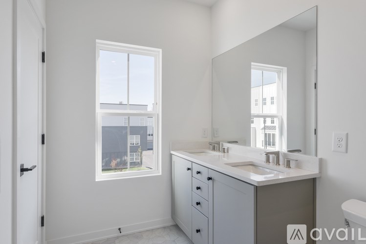 A bathroom with a large mirror and a window overlooking a street.