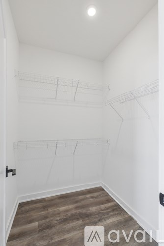 A room with a wooden floor and a wall with a drawing on it.