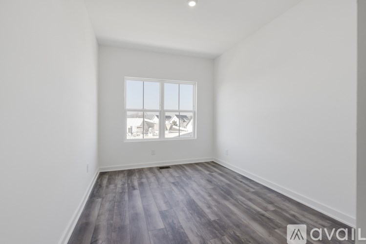 A room with a window showing a view of a house.