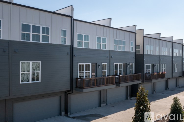 A series of modern townhouses with balconies and garages.