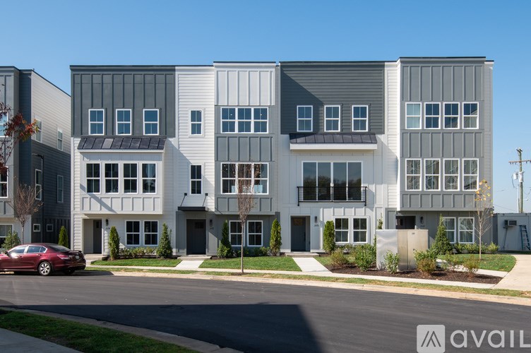 A modern apartment building with a red car parked in front.