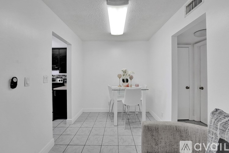A kitchen with a dining table and chairs in the middle of the room.