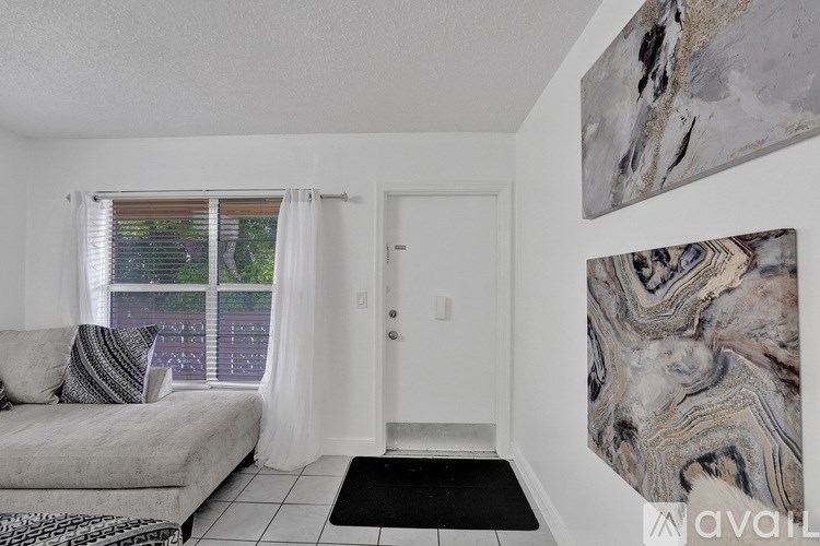A living room with a couch, a rug, and two paintings on the wall.