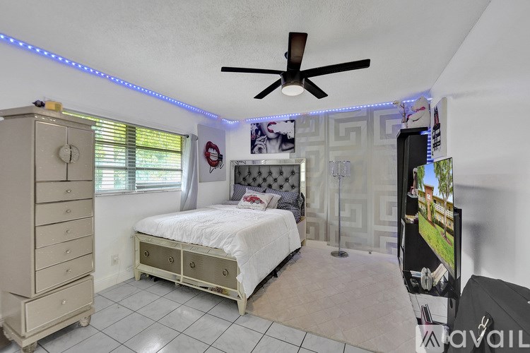 A bedroom with a bed, dresser, and ceiling fan.