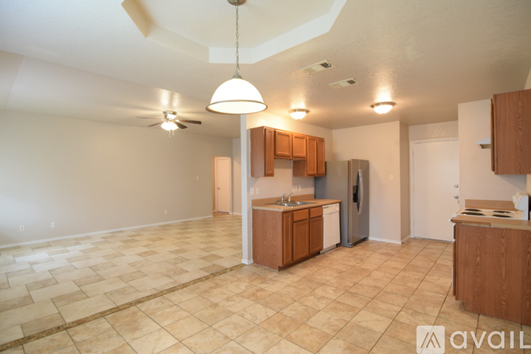 A kitchen with wooden cabinets and a tiled floor.