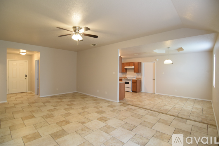 A spacious room with a ceiling fan and tiled flooring.