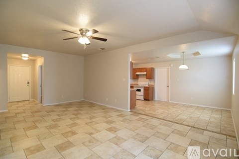A spacious room with a ceiling fan and tiled flooring.