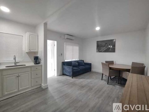 A living room with a couch, table, and chairs.