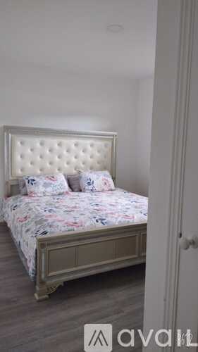 A bed with a floral bedspread and pillows is in the image.
