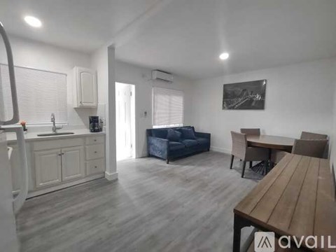 A living room with a blue couch, wooden table, and a painting on the wall.