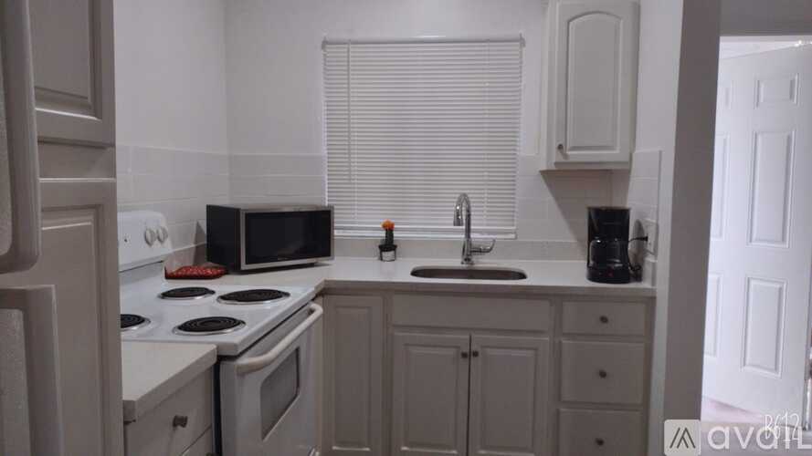 A kitchen with white appliances and cabinets.
