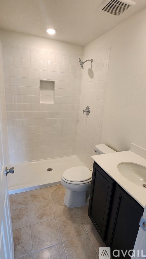 A bathroom with a toilet, sink, and shower.