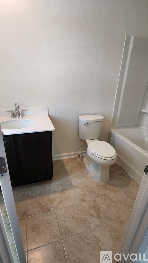 A bathroom with a toilet, sink, and bathtub.