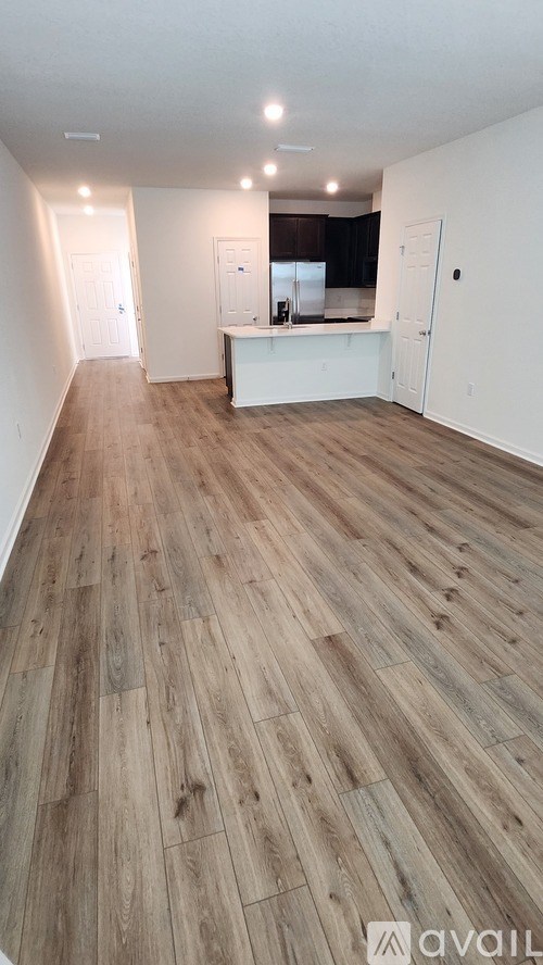 A room with wooden flooring and white walls.