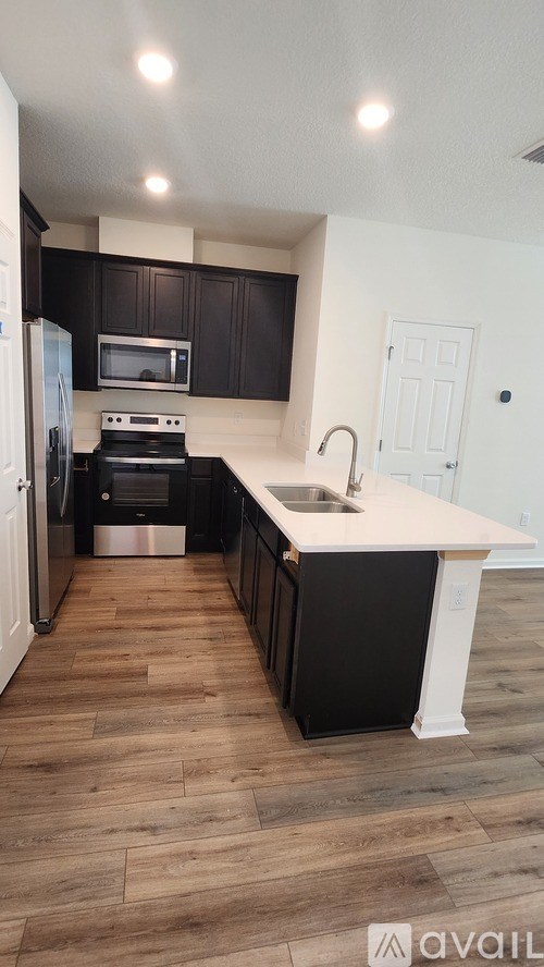 A kitchen with black cabinets and a white countertop.