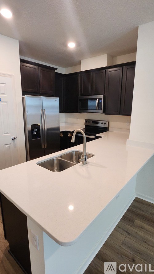 A kitchen with a white counter top and a sink.