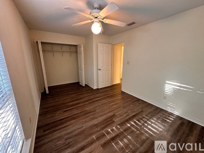 A room with a ceiling fan and carpeted floor.
