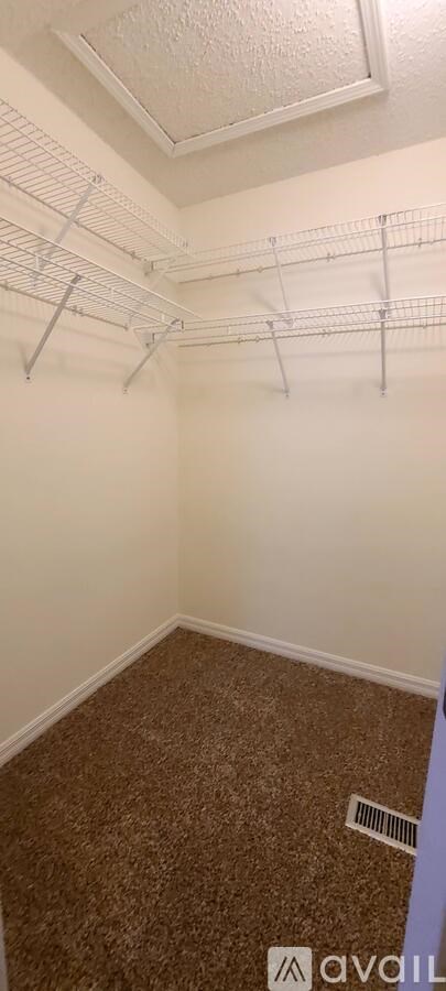 A room with a carpeted floor and a ceiling fan.