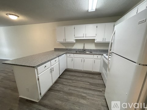 A kitchen with white cabinets and a granite countertop.