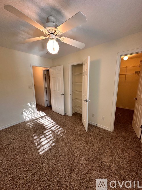 A room with a ceiling fan and wooden flooring.