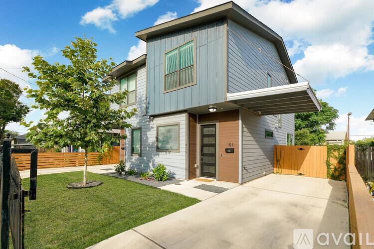 A modern house with a grey exterior and a brown door.