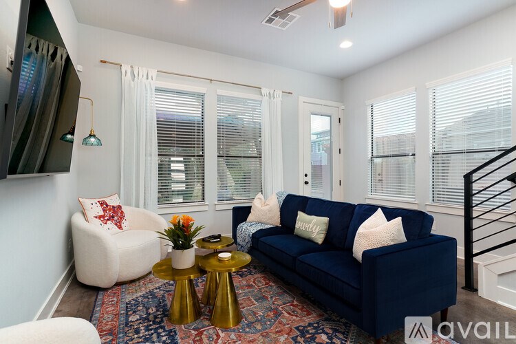 A living room with a blue couch and a white chair.