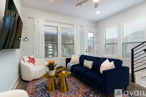 A living room with a blue couch and a white chair.