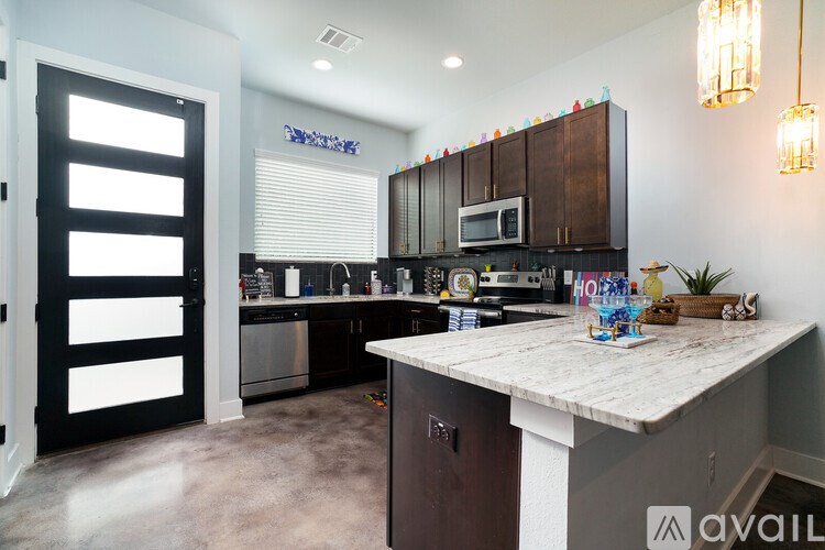 A kitchen with a white countertop and dark brown cabinets.