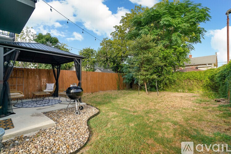 A backyard with a grill and a gazebo.
