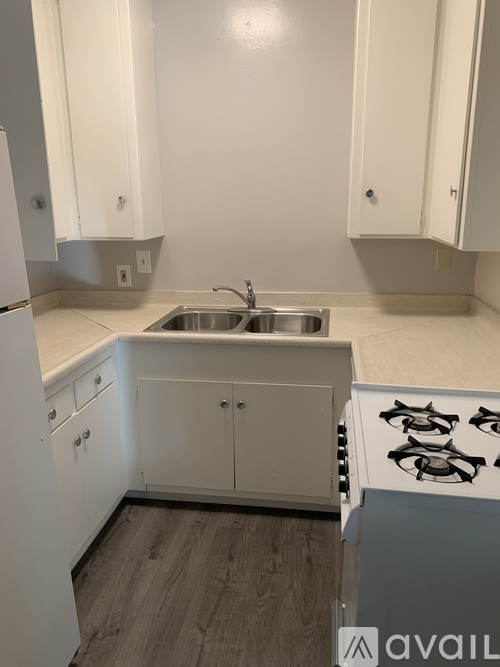 A kitchen with white cabinets and a stove top oven.