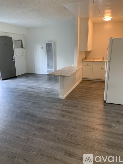 A kitchen with a white fridge and a wooden island.
