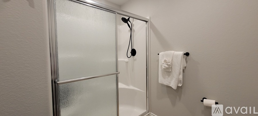 A white towel hangs on a towel rack in a bathroom.